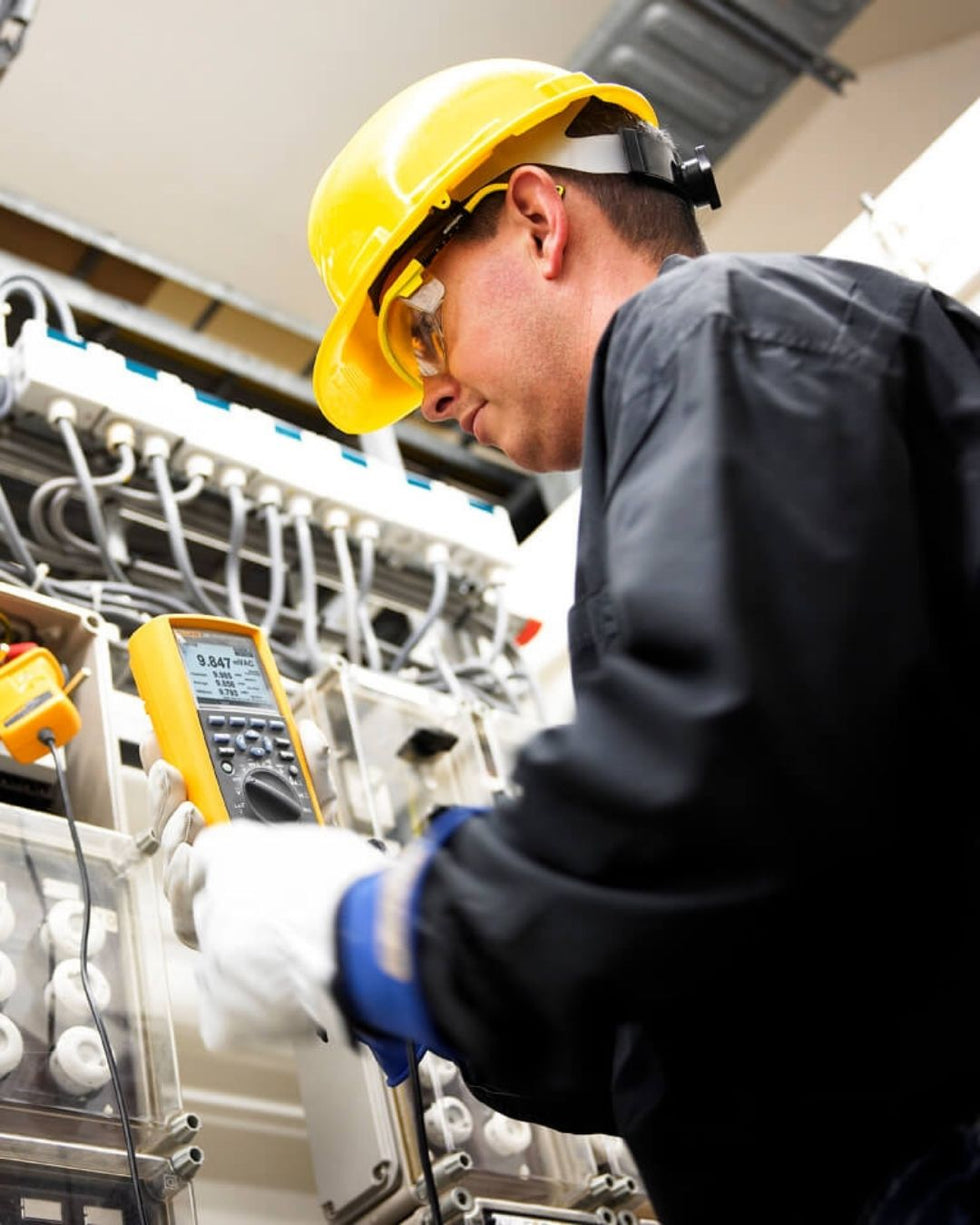 Técnico realizando mediciones eléctricas con multímetro